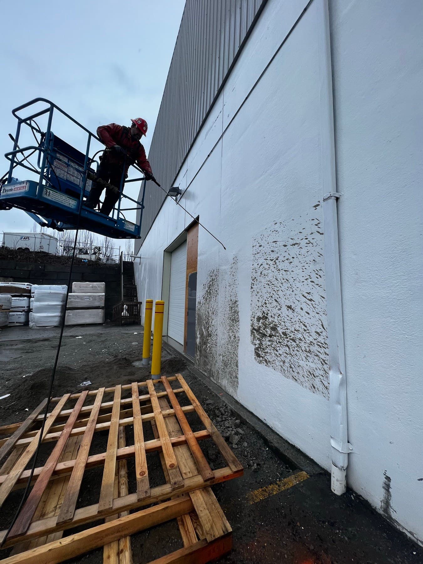 Warehouse soffit half pressure washed clean, half still covered in mold and grime